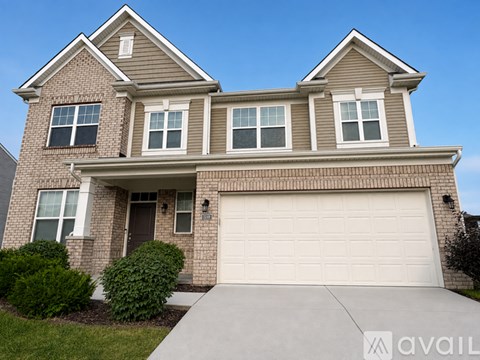 A two-story house with a garage and a driveway.