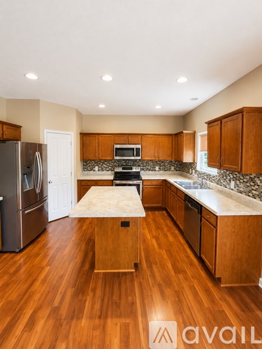A kitchen with wooden cabinets and a marble backsplash.