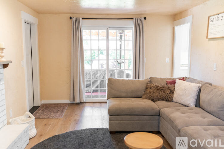 A living room with a grey couch and a fireplace.