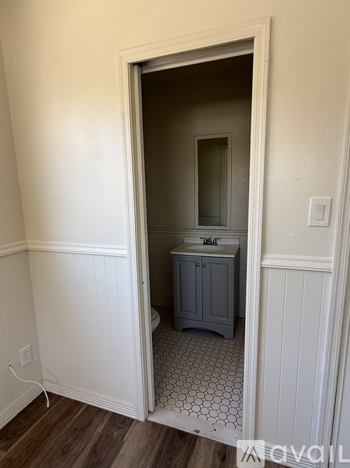 A bathroom with a white cabinet and a mirror is shown.