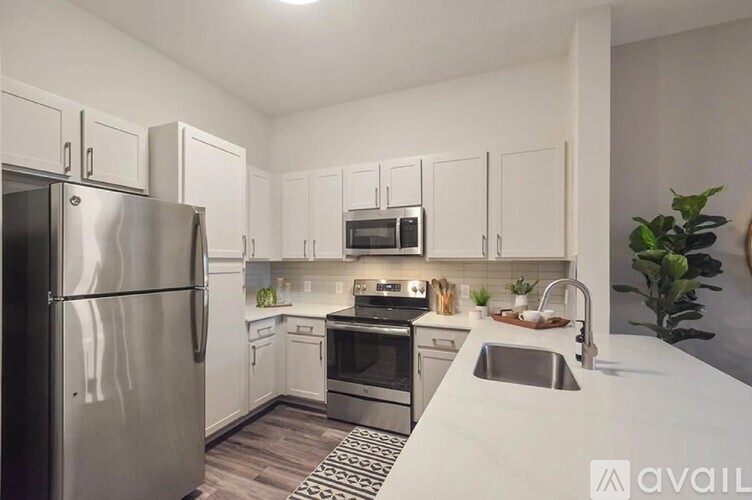 A modern kitchen with stainless steel appliances and white cabinets.