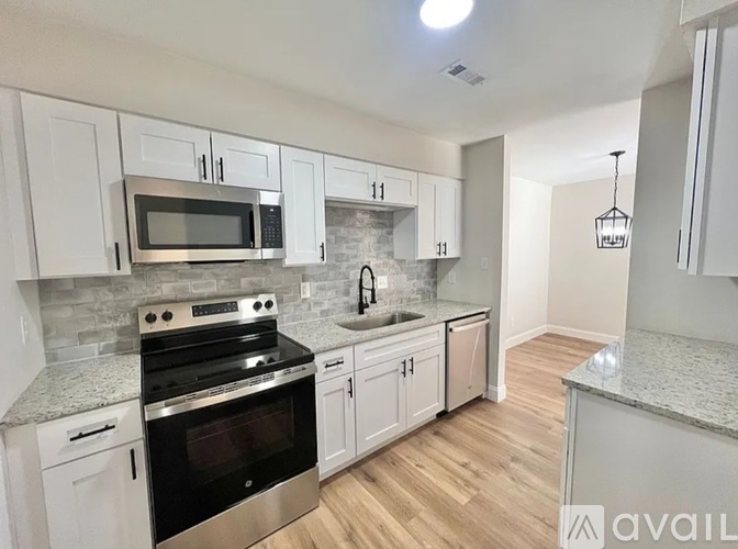 A kitchen with white cabinets and a granite countertop.
