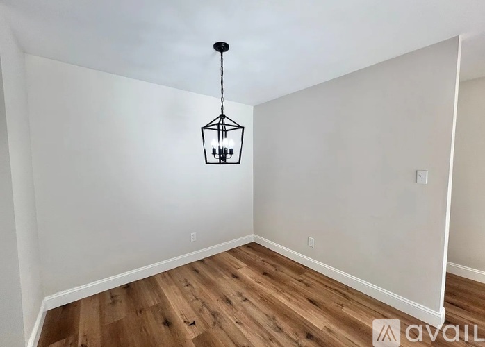 A room with wooden floors and a hanging light fixture.
