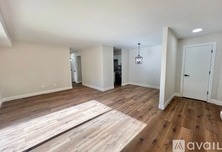A room with wooden flooring and a hanging light fixture.