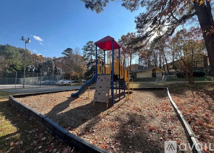 A playground with a red and blue slide and a yellow structure.