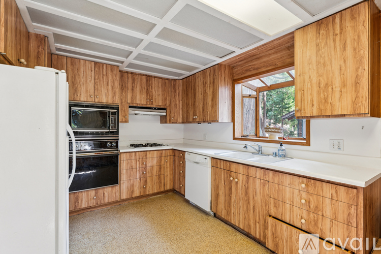 A kitchen with wooden cabinets and a white refrigerator.