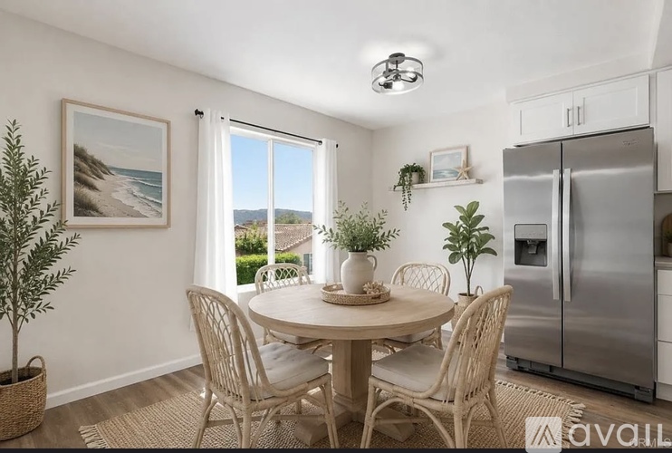 A dining room with a table set for four and a view of the beach.