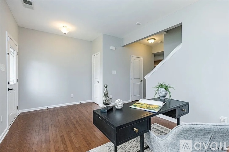 A room with a black desk and a couch.