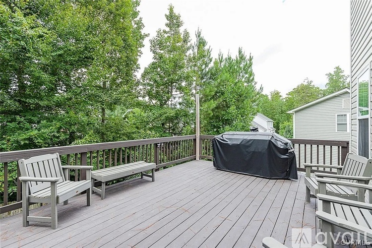 A hot tub on a wooden deck surrounded by trees.