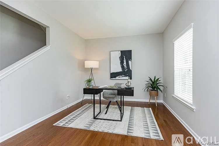 A room with a desk and a chair in it.
