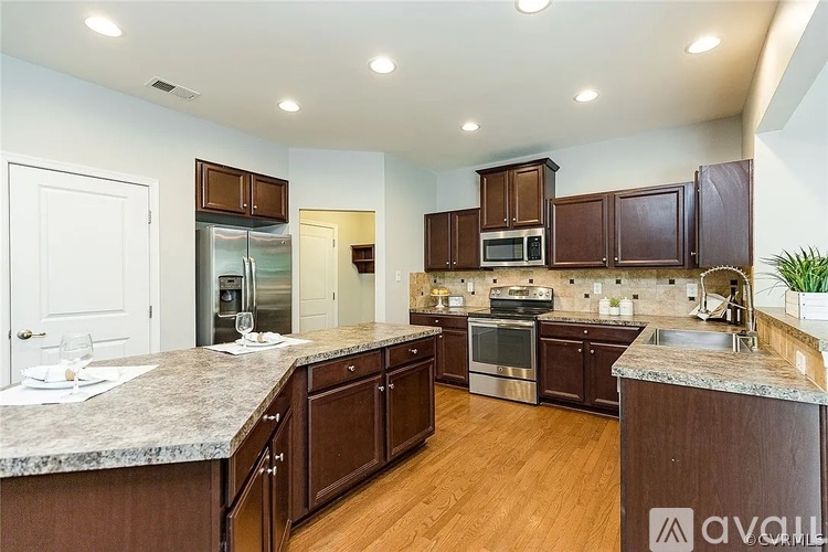 A kitchen with brown cabinets and a granite countertop.