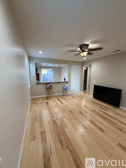 A room with wooden flooring and a ceiling fan.