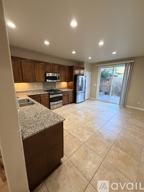 A kitchen with granite countertops and a refrigerator in the background.