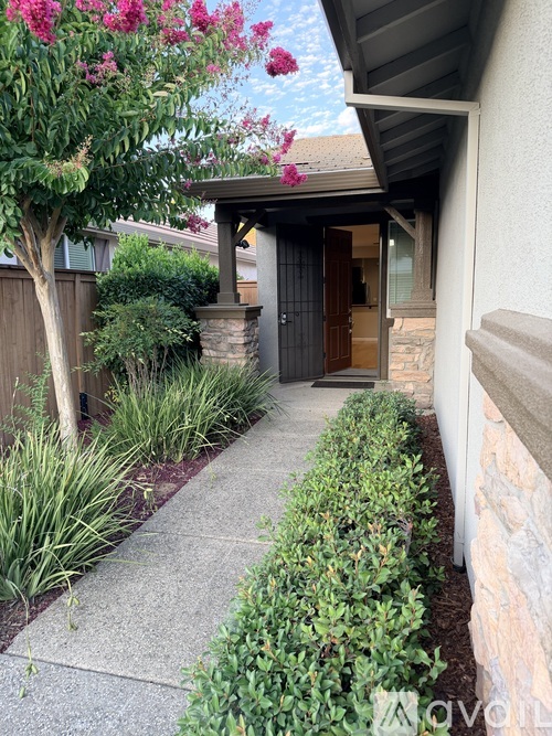 A house entrance with a brown door and a stone pillar.