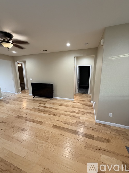 A room with wooden flooring and a ceiling fan.