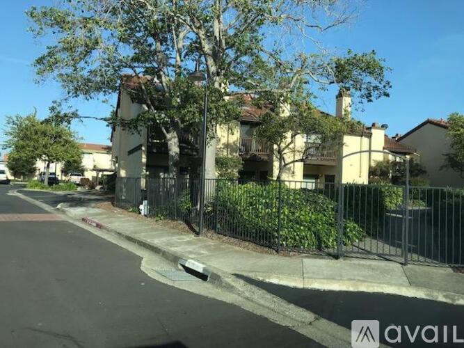 A street view of a residential area with houses and trees.
