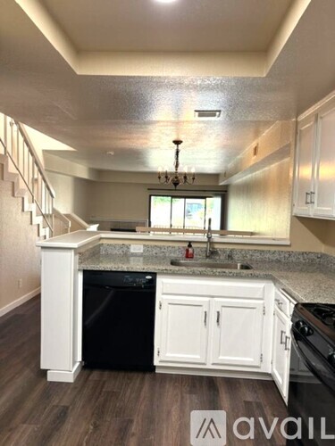 A kitchen with white cabinets and a black dishwasher.