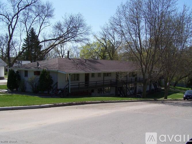 A house with a brown roof is surrounded by trees.