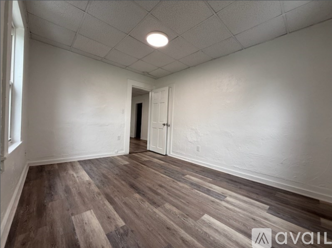A room with wooden flooring and a white door.