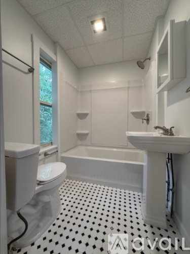 A white bathroom with a black and white floor.