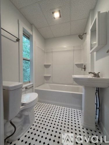 A white bathroom with a black and white floor.