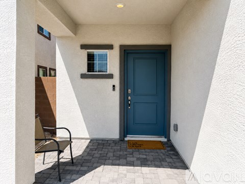 A blue door is on the right side of a white wall.