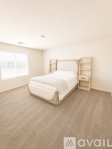 A bedroom with a bed, nightstand, and window.