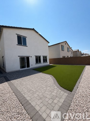 A white house with a grey tiled walkway in front.