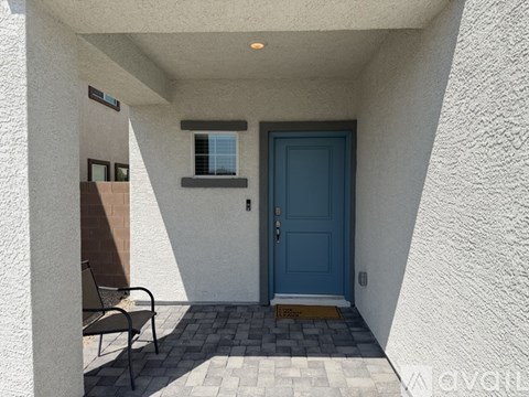 A blue door is on the right side of a white wall.