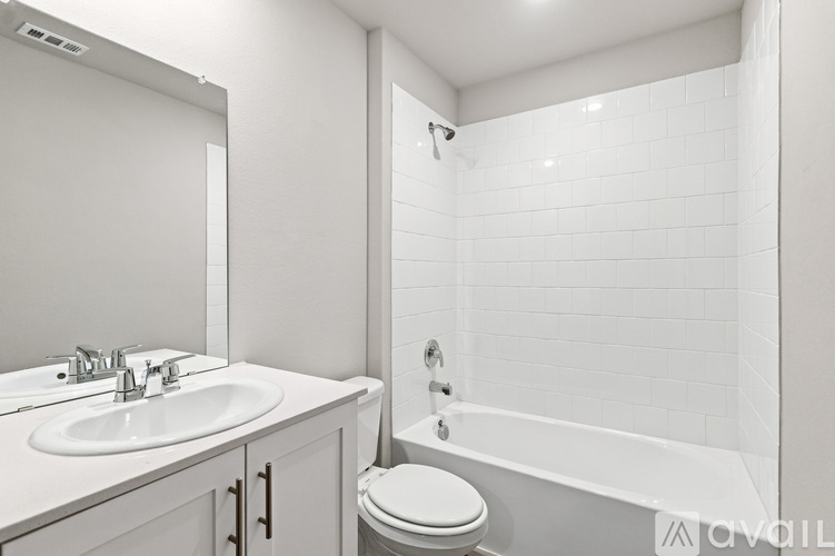A white bathroom with a sink, toilet, and bathtub.