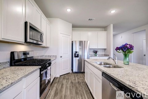 A kitchen with white cabinets and a granite countertop.