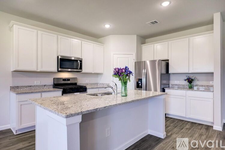 A kitchen with white cabinets and a granite countertop.