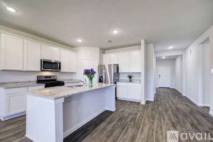 A kitchen with white cabinets and a granite countertop.