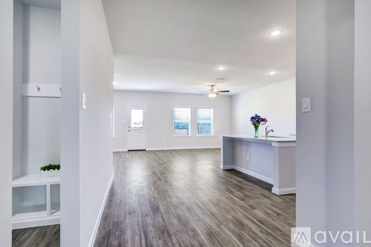 A spacious room with a long counter and a vase of flowers on it.