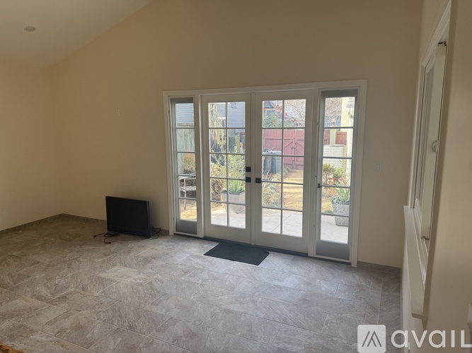 A room with a television and sliding glass doors.