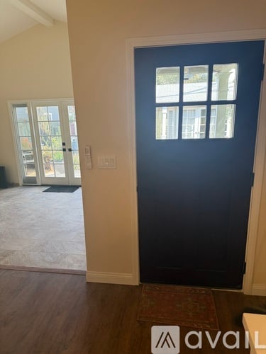 A room with a dark blue door and a window.