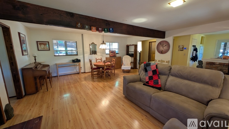 A living room with a grey couch and wooden floors.