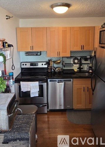 A kitchen with wooden cabinets and a black stove top oven.