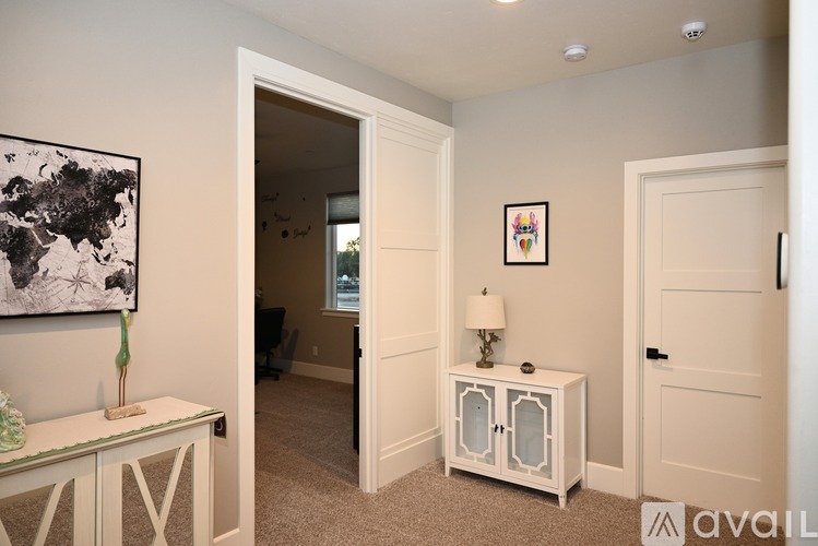 A room with a white cabinet and a framed picture on the wall.