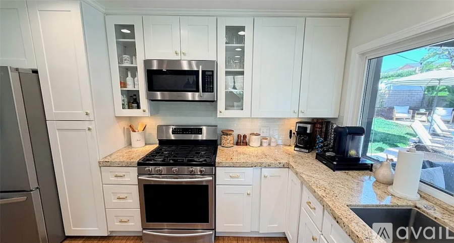 A kitchen with white cabinets and stainless steel appliances.