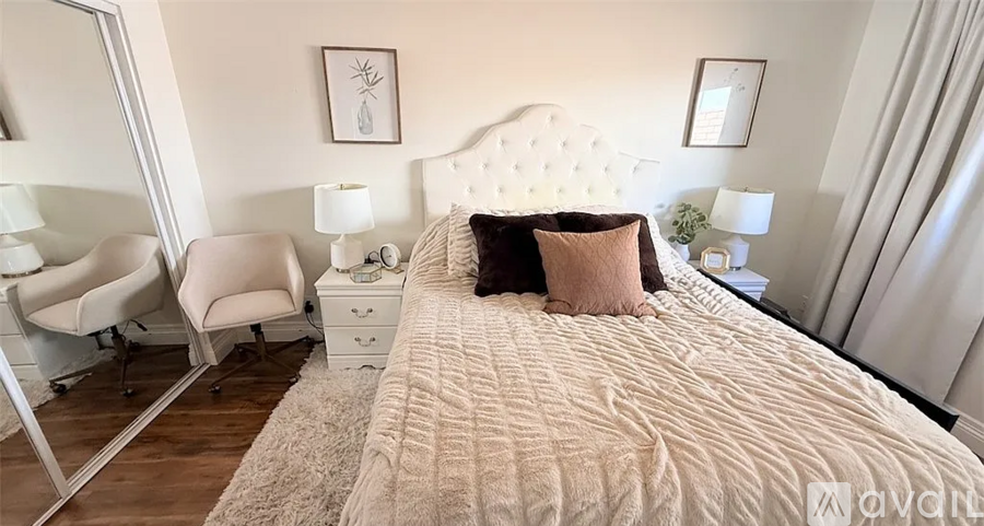 A bedroom with a large bed and a chair.