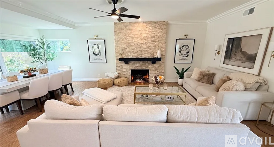 A living room with a white couch and a fireplace.