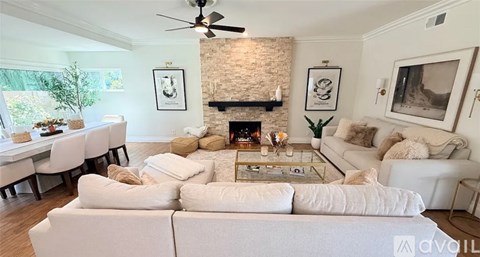 A living room with a white couch and a fireplace.