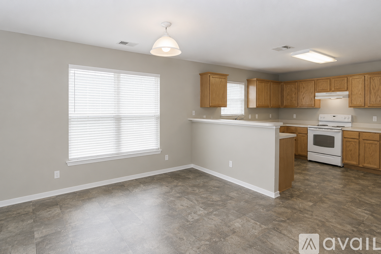 A kitchen with a white stove and wooden cabinets.