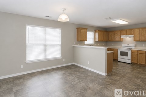 A kitchen with a white stove and wooden cabinets.