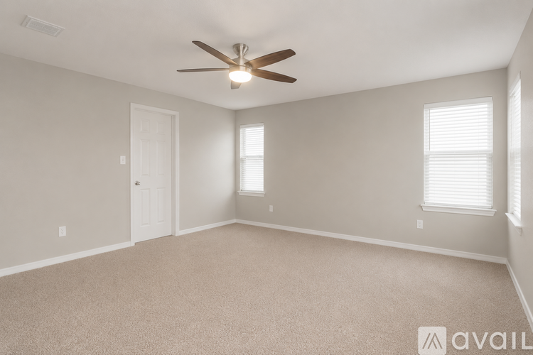 A room with a ceiling fan and carpeted floor.