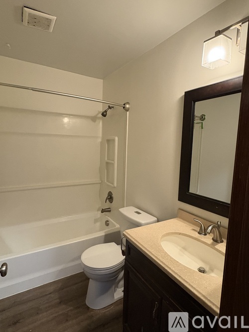 A bathroom with a toilet, sink, and mirror.
