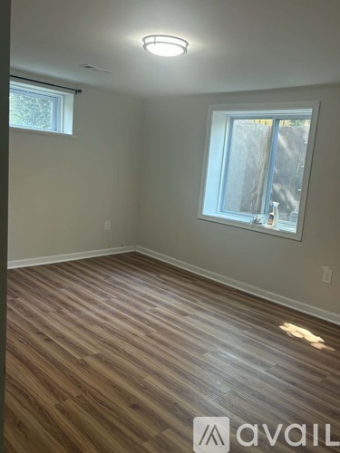 A room with wooden flooring and a window.
