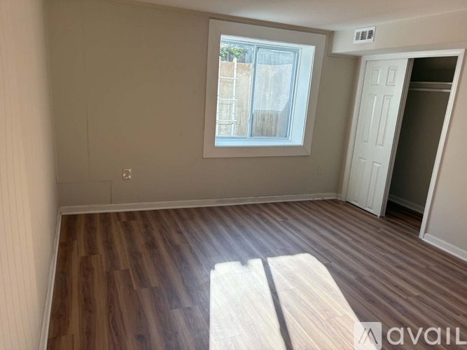 A room with wooden flooring and a window.