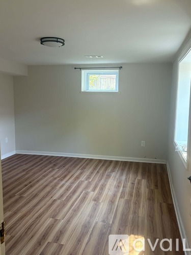 A room with wooden flooring and a window.